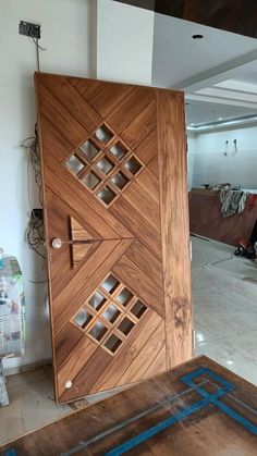 a large wooden door in the middle of a room with blue tape on the floor