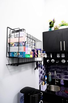 a kitchen area with black cabinets and shelves