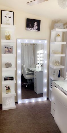 a room with a mirror, desk and shelves filled with lights on it's sides