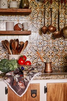 the kitchen counter is covered with various cooking utensils and bowls, including tomatoes