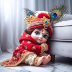 a small doll sitting on top of a couch wearing a red dress and headdress