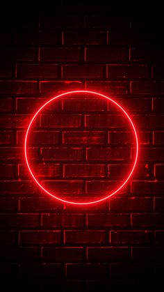 a red neon circle on a brick wall