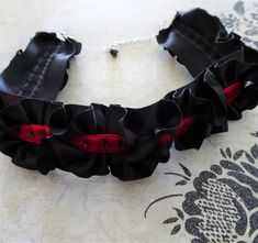 Ruffled black satin is embroidered stitched with a red velvet ribbon to make up this steampunk style costume choker necklace.  The satin and ribbon are crimped with silver metal crimp bars and linked to a matching silver extension chain. There is a black glass bead dangle linked on the chain.  Perfect costume jewelry accessory for the old western, saloon girl look. The choker closes at 13" on first link and with the extension chain adds adjustable sizing to 15".  the width of the choker is 1 1/2".  There is a silver hook closure on the choker. All of my jewelry comes boxed, and ribbon tied and tagged for easy gifting. Old West Costume, Western Saloon Girl, Halloween Choker, Saloon Girl Costumes, Satin Choker, Saloon Girl, Western Saloon, Ribbon Choker Necklace, Girls Choker