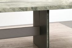 a marble top table with metal legs on a wood floor