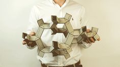 a man is holding up some cubes in front of his face while wearing a white shirt