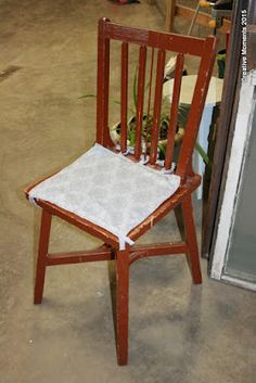 a wooden chair with a white seat cushion