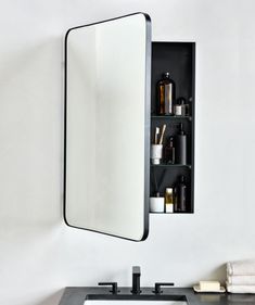 a bathroom sink sitting under a mirror next to a wall mounted medicine cabinet