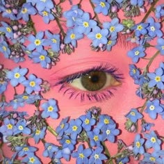 a woman's eye surrounded by blue flowers