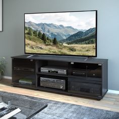 a flat screen tv sitting on top of a wooden entertainment center in a living room