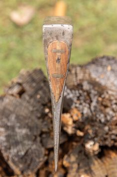 a wooden spoon with a metal handle in the shape of a heart on it's tip