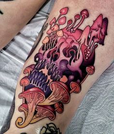 a colorful tattoo on the leg of a man with mushrooms and other things around him