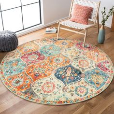 a round rug with an orange, blue, yellow and red design on it in a living room