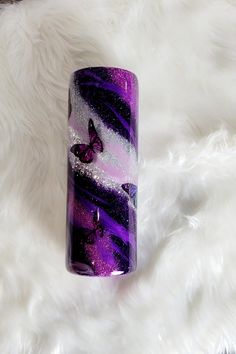 a purple and black glass tube sitting on top of a white rug