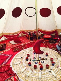 the inside of a yurt with candles and rugs on the floor in front of it