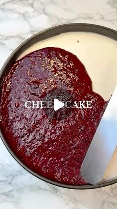 a knife is being used to cut into a cake in a pan on a marble table