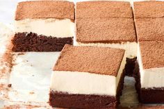 several pieces of cake sitting on top of a white and brown paper covered baking sheet