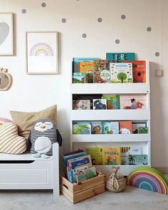 a child's room with bookshelves, toys and pictures on the wall