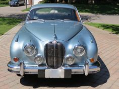 an old blue car is parked in front of a house