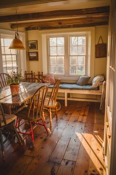 a table and chairs in a room with wooden floors, windows, and wood flooring