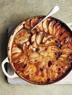 a pan filled with food sitting on top of a counter next to a knife and fork