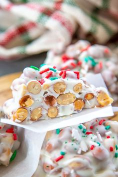 some kind of candy bar sitting on top of a wooden board with white frosting and sprinkles