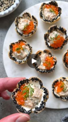 someone is holding up small appetizers on a plate