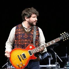 a man is playing an electric guitar on stage