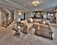 a living room filled with furniture and a staircase leading up to the second floor area