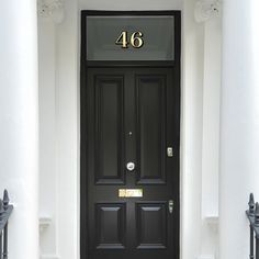 a black front door with the number 46 on it's side and two white pillars