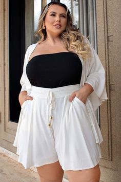 Cropped Plus Size Sem Alça Preto. Dê um toque de elegância e conforto ao seu guarda-roupa com o nosso cropped. Confeccionado em malha ribana canelada, este top apresenta uma modelagem soltinha que abraça suas curvas de forma suave. Projetado com cuidado, o elástico embutido garante um ajuste perfeito ao redor do busto, oferecendo suporte e segurança durante todo o dia. Além disso, o forro com elástico frontal proporciona sustentaç&atil Plus Size Tshirt Outfits, Plus Size Crop Top, Crop Top Plus Size, Blazer E Short, Cropped Plus Size, Plus Size Crop Tops, Top Moda