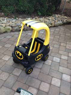 a little kid's batman tricycle on the ground