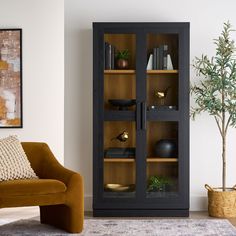 a brown chair sitting next to a tall wooden cabinet