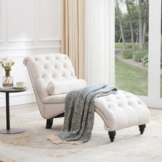 a white chair and ottoman in front of a sliding glass door with an open window