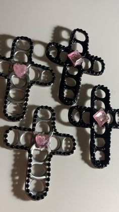 four pieces of black metal with pink hearts on them