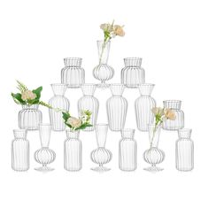 a large group of vases with flowers in them on a white background, all stacked up together