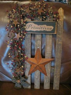 an old wooden crate with a primitive sign and star on the front is adorned with red berries