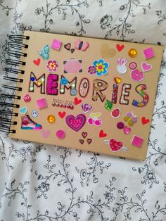 a notebook with the word memories written on it and lots of magnets attached to it