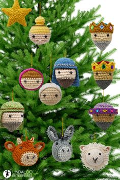 crocheted christmas tree ornaments with animals and hats hanging from it's branches