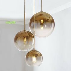 three glass globe lights hanging from a ceiling