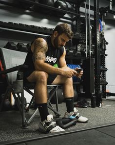 a man sitting in a chair looking at his cell phone