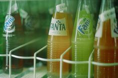 several bottles of soda are lined up on the shelf