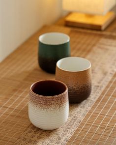 three cups sitting on top of a wooden table