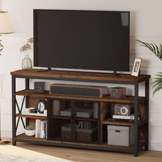 a flat screen tv sitting on top of a wooden shelf