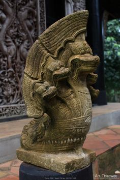 a statue is sitting on a pedestal in front of a building with an intricately carved design