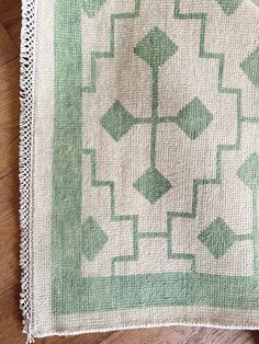 a green and white rug sitting on top of a wooden floor