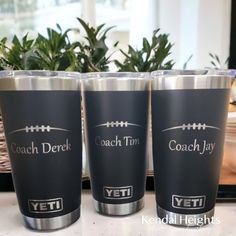 three black yeti cups sitting on top of a counter