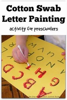 a child's hand is writing on a yellow paper with the words cotton swab letter painting