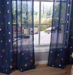 a window with blue curtains and gold stars on it