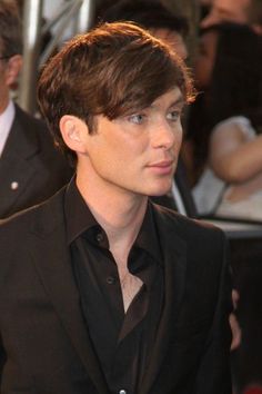 a black and white photo of a man in a suit looking off to the side