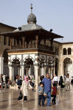 many people are walking around an old building